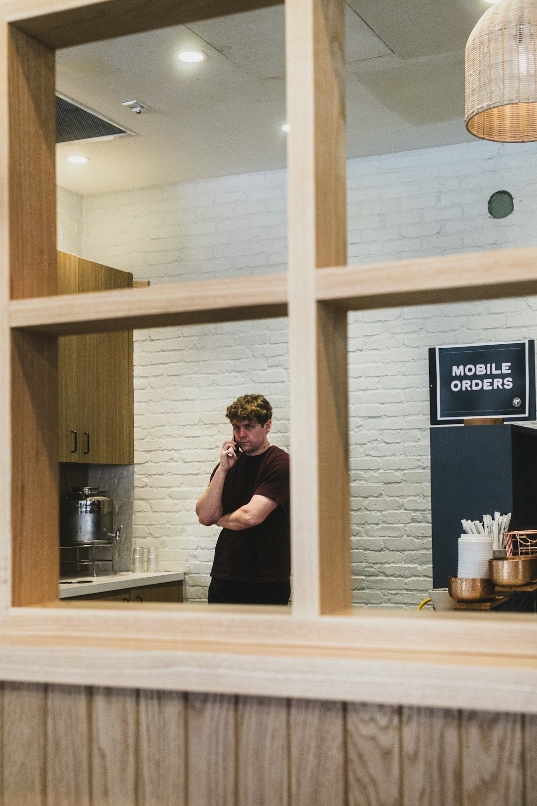 Small business owner on the phone in a cafe, the kind of busy moment where an AI chatbot handles website questions